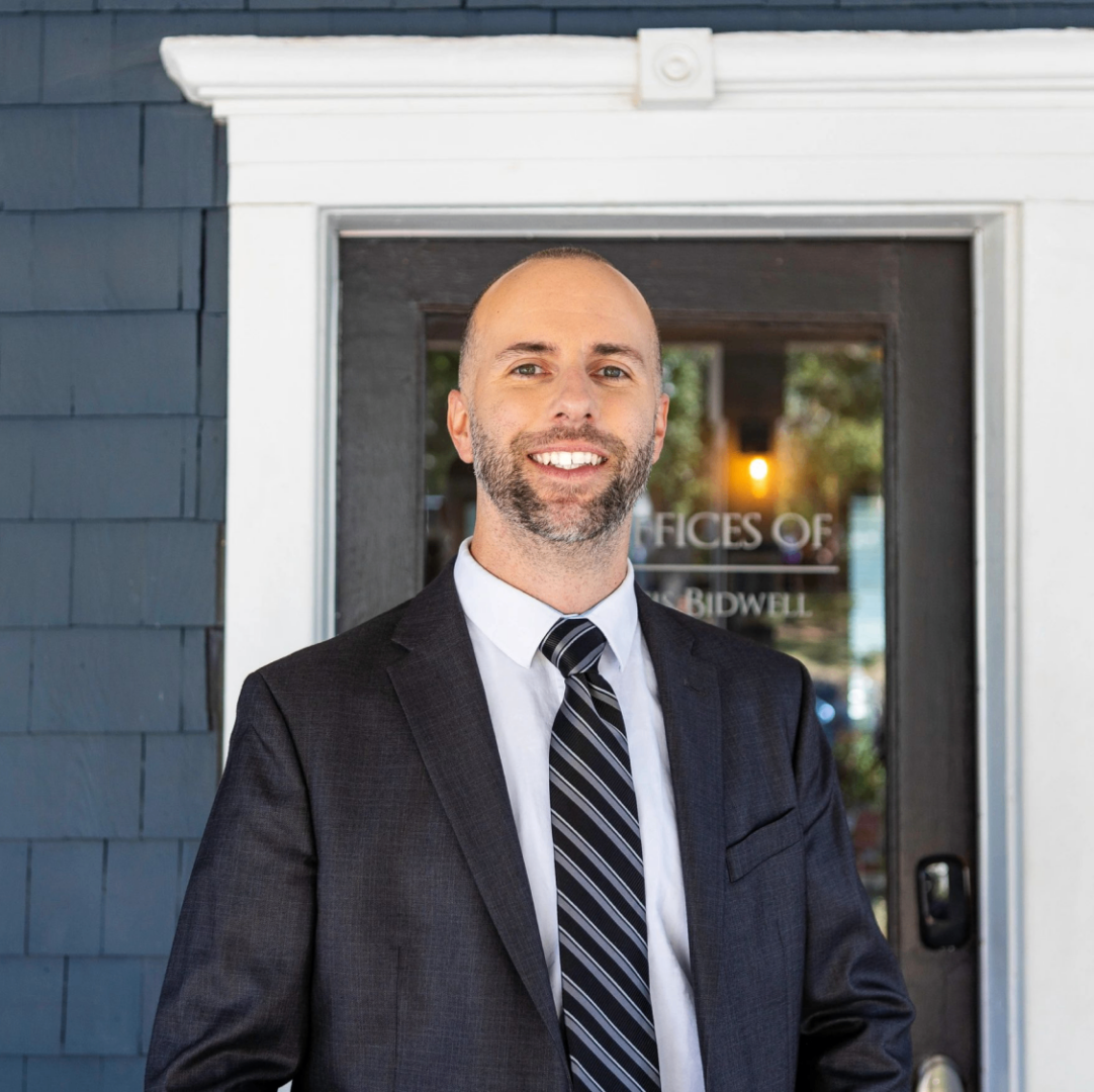 A man in suit and tie standing outside of a building.